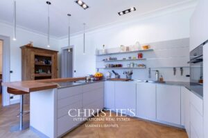 Une cuisine moderne et lumineuse avec des étagères ouvertes et un îlot en bois.