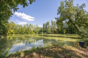 La maison du moulin, située au bord de la rivière Dropt, surplombe son lac et s’étend au cœur d’un domaine boisé de 13 hectares