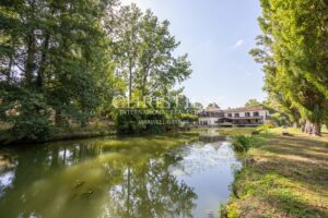 La maison du moulin, située au bord de la rivière Dropt, surplombe son lac et s’étend au cœur d’un domaine boisé de 13 hectares