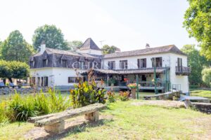 La maison du moulin, située au bord de la rivière Dropt, surplombe son lac et s’étend au cœur d’un domaine boisé de 13 hectares