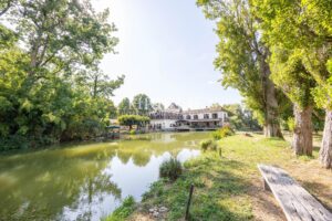 La maison du moulin, située au bord de la rivière Dropt, surplombe son lac et s’étend au cœur d’un domaine boisé de 13 hectares