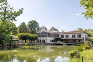 La maison du moulin, située au bord de la rivière Dropt, surplombe son lac et s’étend au cœur d’un domaine boisé de 13 hectares