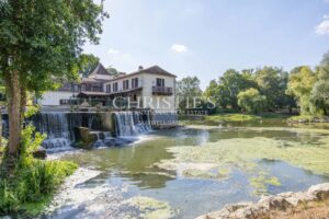 La maison du moulin, située au bord de la rivière Dropt, surplombe son lac et s’étend au cœur d’un domaine boisé de 13 hectares