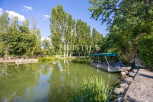 La maison du moulin, située au bord de la rivière Dropt, surplombe son lac et s’étend au cœur d’un domaine boisé de 13 hectares