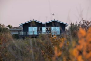 Une maison moderne est visible à travers un feuillage automnal.